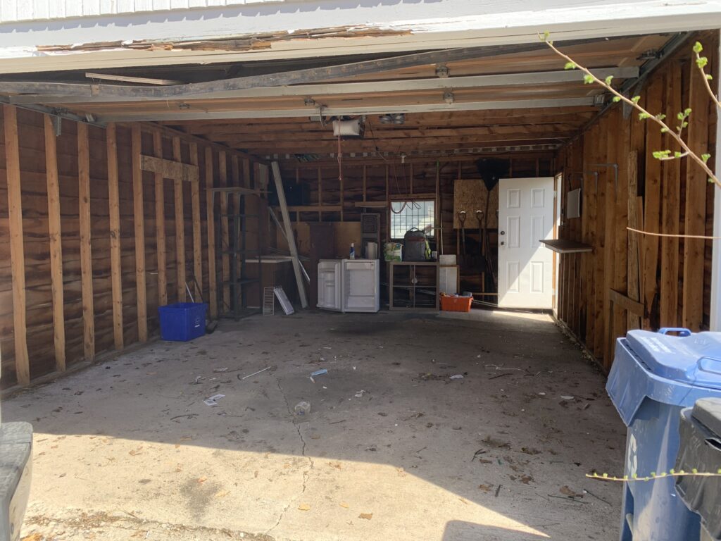 A clean garage that has been recently spring cleaned, and is ready for a car to go inside.