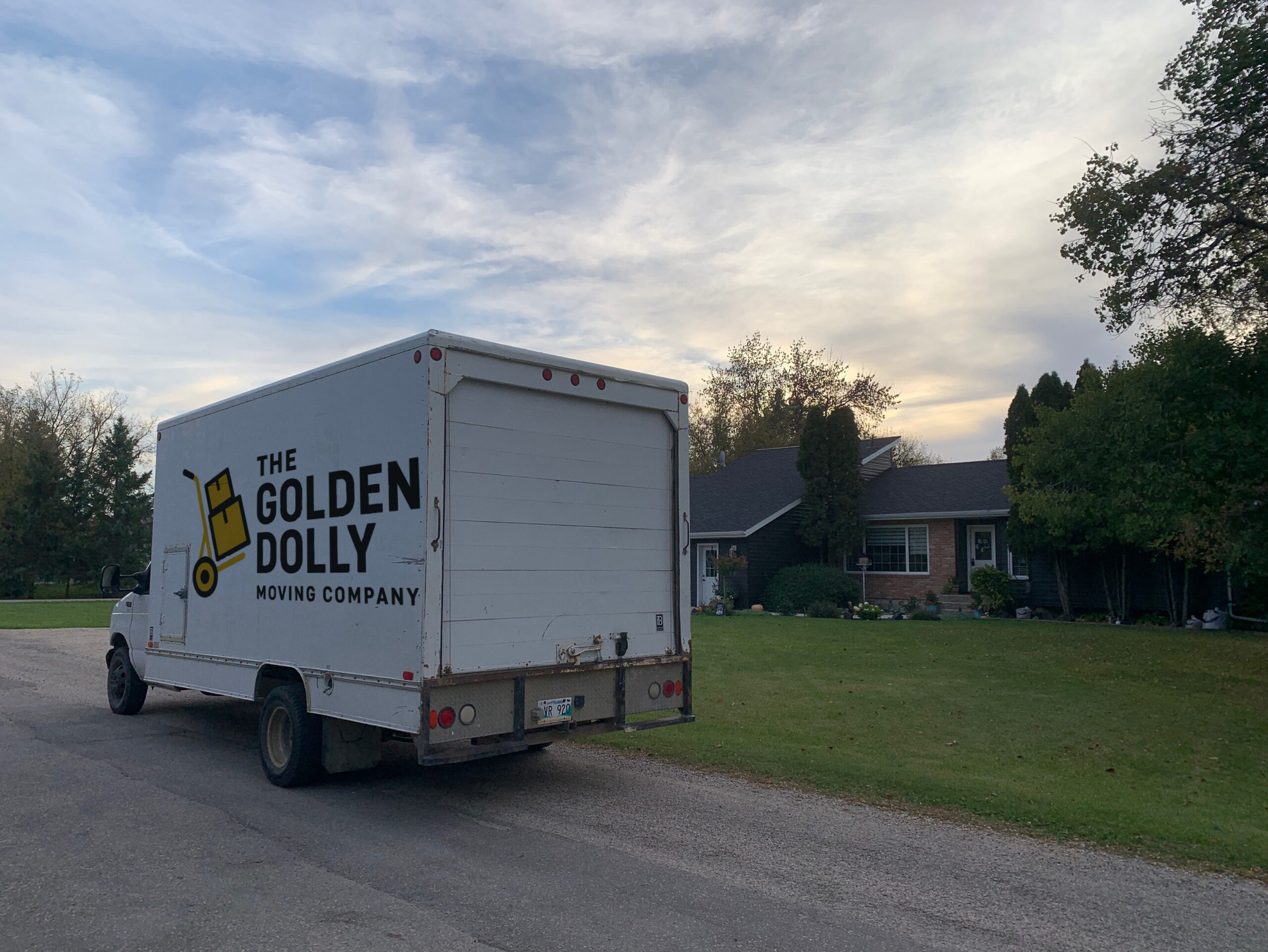 The Golden Dolly Moving Company truck next to a house. your winnipeg movers and winnipeg moving company